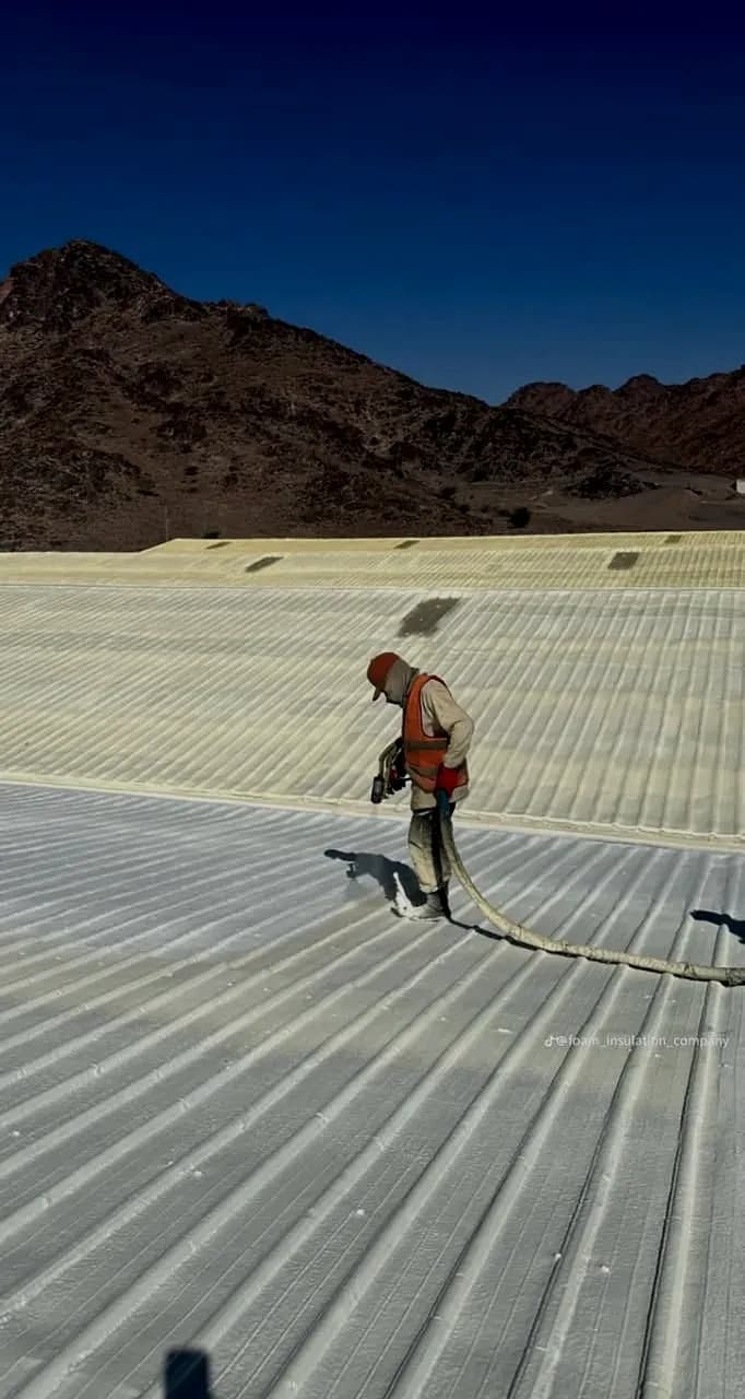 Spray foam application over a corrugated metal roof at a mountain site